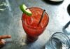 An irish michelada with lime, ice and a straw