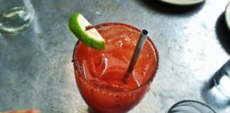 An irish michelada with lime, ice and a straw