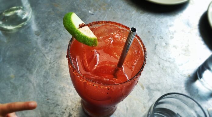 An irish michelada with lime, ice and a straw