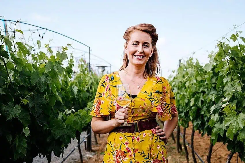 Kris Magnussen standing in a vineyard and holding a glass of wine