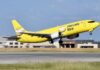 A yellow Mercado Libre airplane takes off from a runway