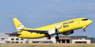 A yellow Mercado Libre airplane takes off from a runway