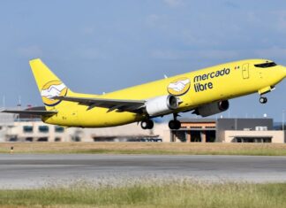 A yellow Mercado Libre airplane takes off from a runway