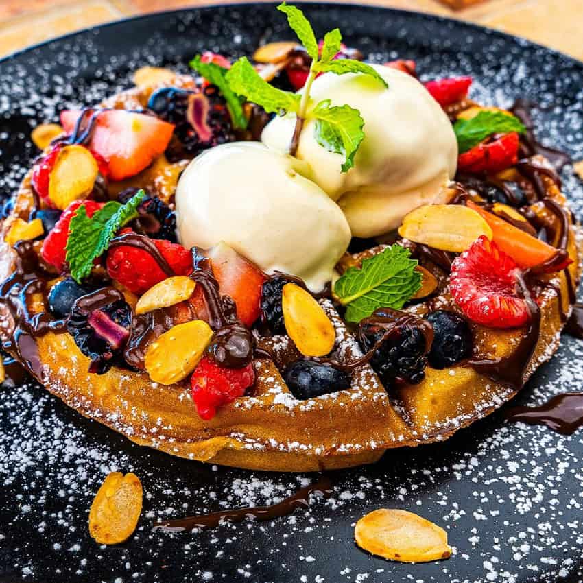 A waffle topped with fruits and cheese at Solomon's Landing Los Cabos