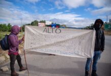 Protestors against Chiapas Highway project hold sign