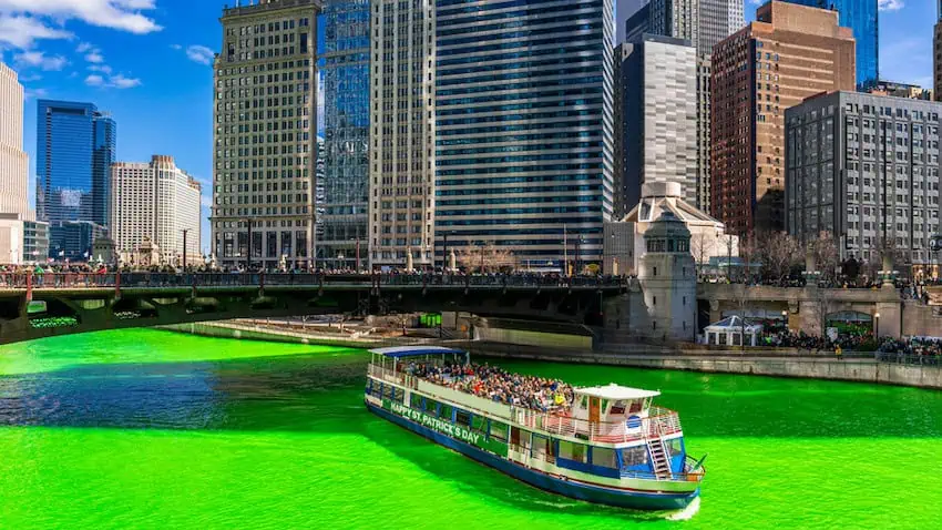 Celebraciones del Día de San Patricio en Chicago, un bote navega por un río verde