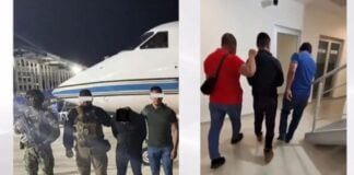 Police and security agents escort a handcuffed suspect onto a plane