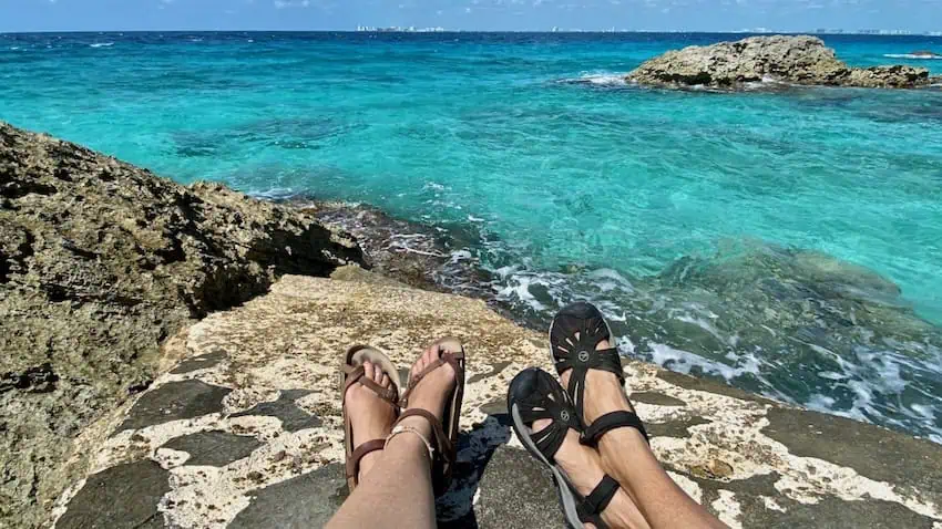 Two pairs of feet on the Caribbean coastline