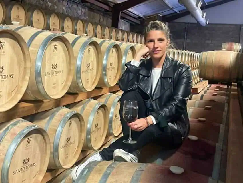 Winemaker Cristina Pino posing by casks of wine.