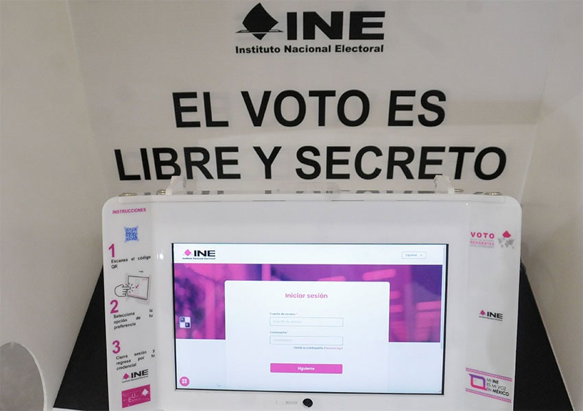 An INE electronic voting booth with a sign reading "El voto es libre y secreto"