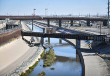 The channelized Rio Grande runs under rail bridges on the border between El Paso and Ciudad Juárez