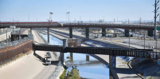 The channelized Rio Grande runs under rail bridges on the border between El Paso and Ciudad Juárez