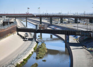 The channelized Rio Grande runs under rail bridges on the border between El Paso and Ciudad Juárez