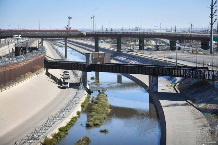 The channelized Rio Grande runs under rail bridges on the border between El Paso and Ciudad Juárez