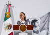 President Claudia Sheinbaum stands at a podium at her morning press conference