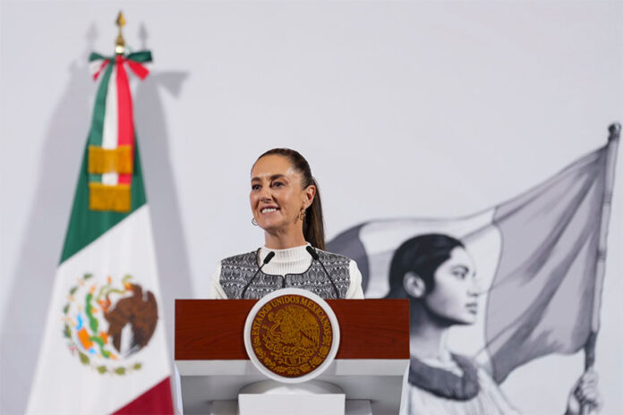 President Claudia Sheinbaum stands at a podium at her morning press conference