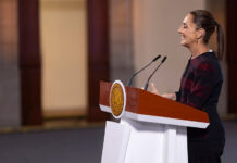 President Claudia Sheinbaum stands at a podium during her morning press conference