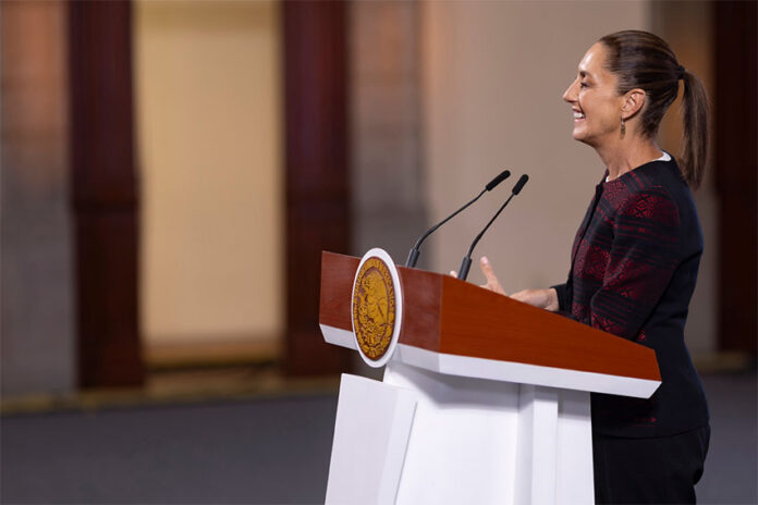 President Claudia Sheinbaum stands at a podium during her morning press conference