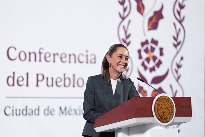 President Claudia Sheinbaum stands at a podium smiling