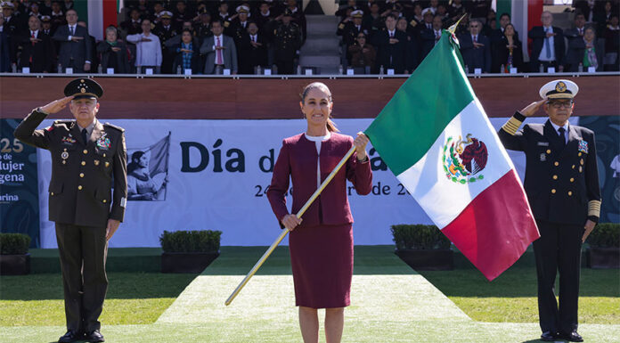 President Sheinbaum carries a Mexican flag, flanked by military