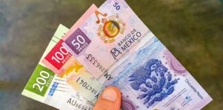 A hand holding three Mexican currency bills: the 200 pesos bill, the 100 peso bill and the 50 peso bills