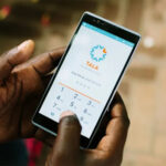 Hands hold a phone with the Tala microlending application open