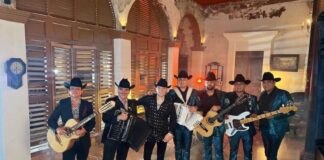 Los Alegres de Barranco band poses with instruments and cowboy hats