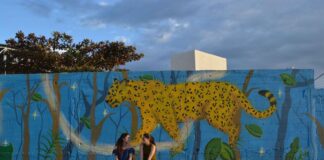 people enjoying a slow pace of life in front of a mural in Campeche, Mexico