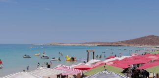 People sunbathing under beach umbrellas on a Baja Caliornia Sur beach