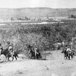 Black and white period photo of military men on horseback riding through the Baja California Peninsula