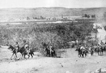 Black and white period photo of military men on horseback riding through the Baja California Peninsula