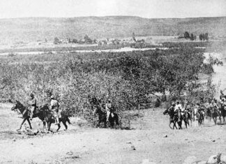 Black and white period photo of military men on horseback riding through the Baja California Peninsula