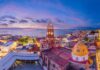Skyline of Puerto Vallarta, with the Pacific Ocean in the background and buildings with Arabic-style domes in the foreground.