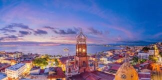 Skyline of Puerto Vallarta, with the Pacific Ocean in the background and buildings with Arabic-style domes in the foreground.