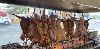 Cabrito being cooked over hot coals