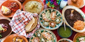 A spread of different types of Oaxaca food including tlyaudas, mole and tortillas.