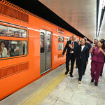 President Sheinbaum, CDMX Mayor Clara Brugada and other officials walk along a Mexico City Metro platform next to an orange train