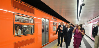 President Sheinbaum, CDMX Mayor Clara Brugada and other officials walk along a Mexico City Metro platform next to an orange train
