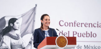 President Sheinbaum smiles from the podium of her morning press conference