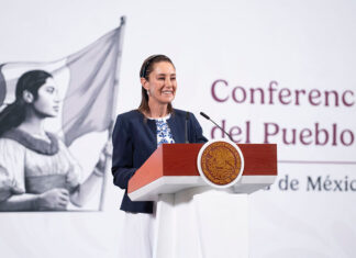 President Sheinbaum smiles from the podium of her morning press conference