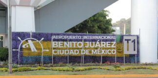 Sign along an airport roadway that says Aeropuerto Internacional Benito Juarez Ciudad de Mexico