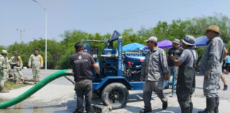 Workers for disaster relief agency clear floodwaters in Reynosa