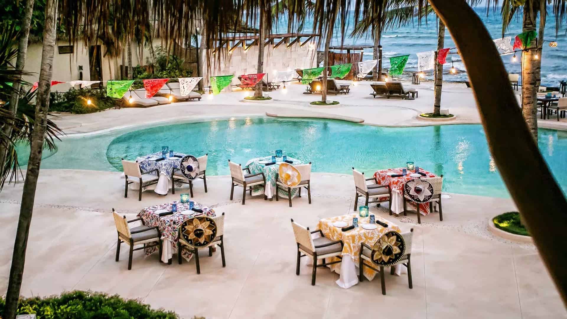 Tables set up poolside at a hotel with Cinco de Mayo decorations