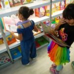 Young children looking at books at a book fair.