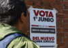 A man looks at a poster reading "Vote June 1 for the new judicial power" in Spanish