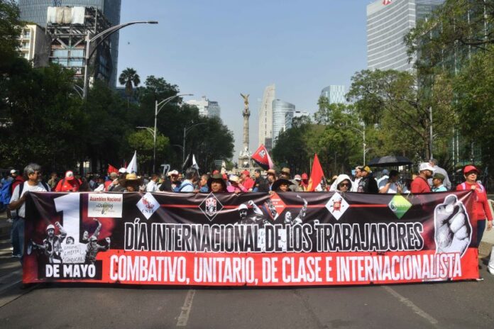 Protesters hold a large banner reading 