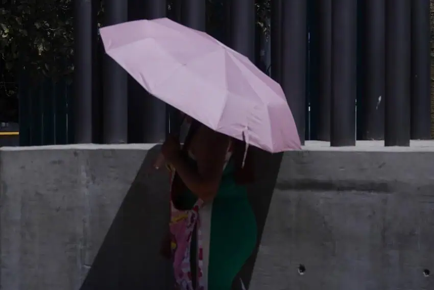 person protecting from soun with umbrella