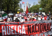 Teachers march down Reforma Avenue in Mexico City with a banner reading "Huelga Nacional"