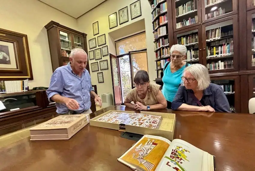 A group of elderly in front of a bookshelf at a library in Okshaka