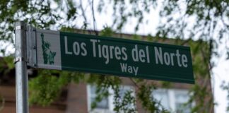 A street sign with the words "Los Tigres del Norte Way"